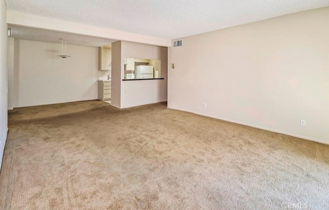 unfurnished living room with a textured ceiling and carpet