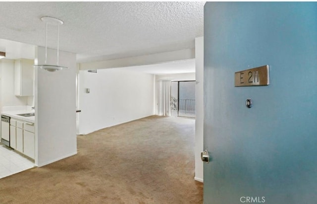 interior space featuring light colored carpet and a textured ceiling