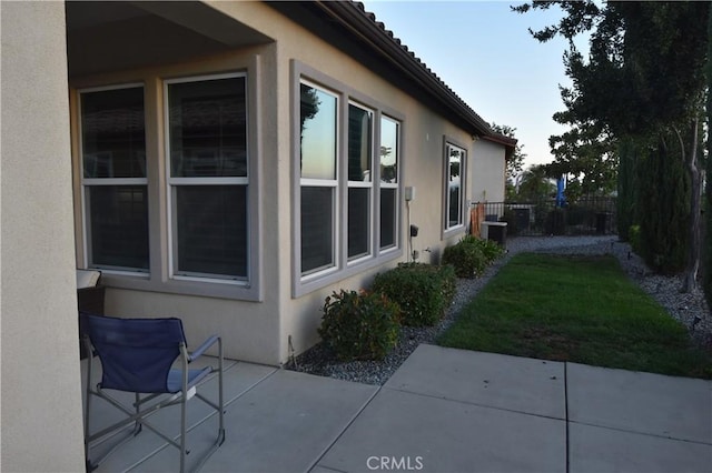 view of side of home featuring a patio area and a yard