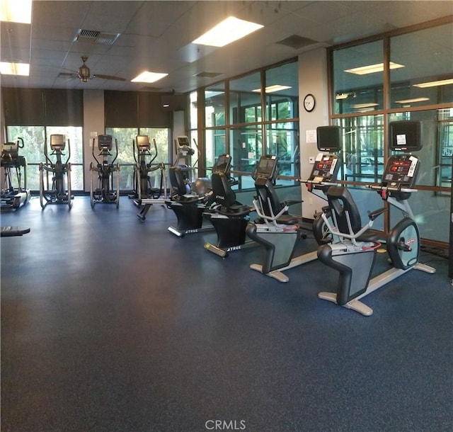 exercise room with a paneled ceiling and ceiling fan