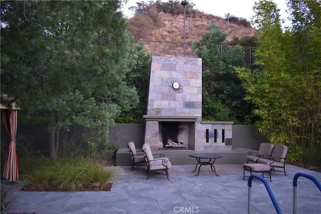 view of patio with an outdoor fireplace