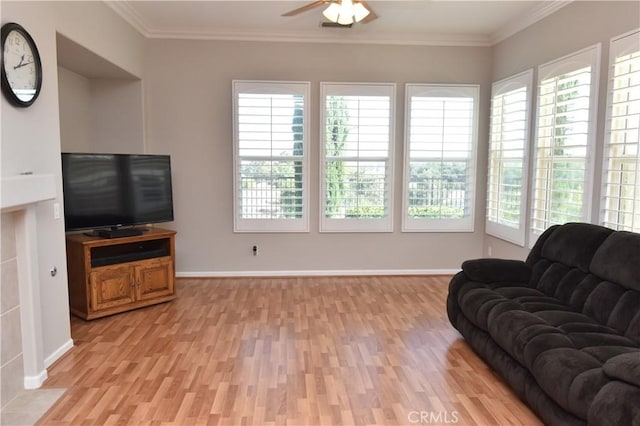 living room with ceiling fan, ornamental molding, and light wood-type flooring