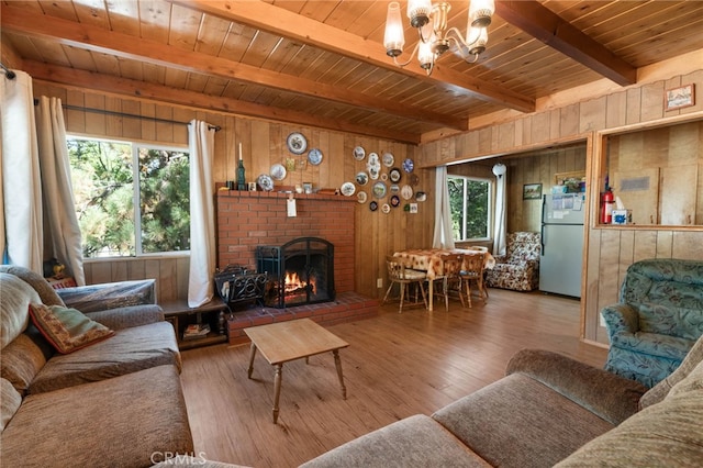 living room with an inviting chandelier, wood walls, and a fireplace