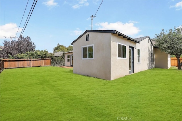 rear view of house featuring a yard