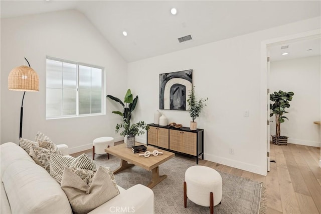 living area featuring recessed lighting, visible vents, baseboards, vaulted ceiling, and light wood-style floors