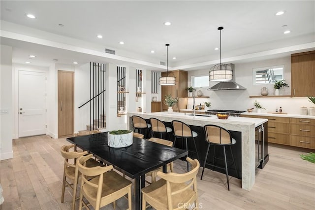 dining space with stairway, light wood-type flooring, visible vents, and recessed lighting