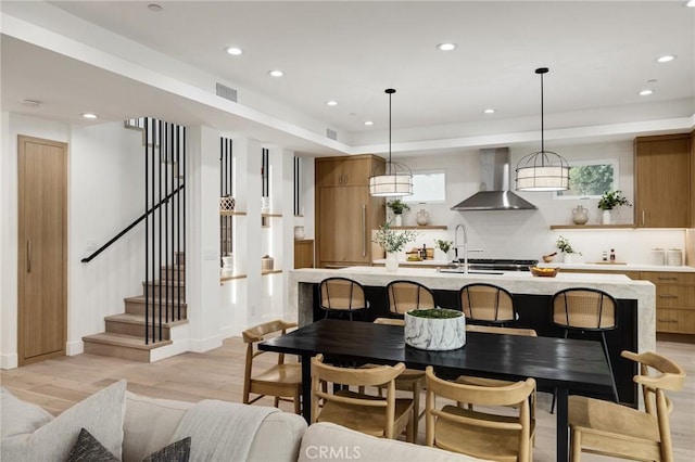 dining room featuring recessed lighting, visible vents, light wood-style floors, baseboards, and stairs