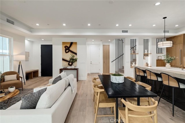 living area featuring stairs, recessed lighting, visible vents, and light wood-style floors