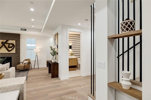 interior space featuring light wood-style flooring, a fireplace, baseboards, and recessed lighting