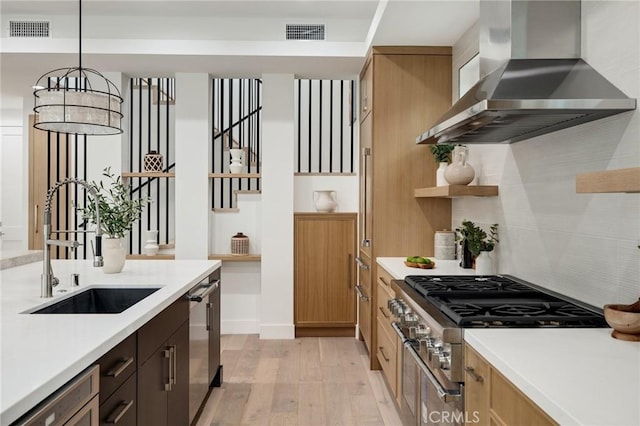 kitchen featuring open shelves, light countertops, visible vents, a sink, and wall chimney range hood