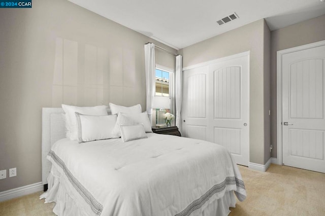 bedroom featuring light carpet and a closet