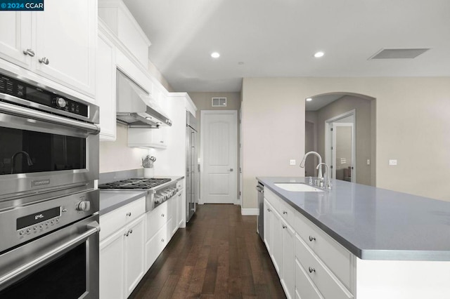 kitchen with a kitchen island with sink, dark hardwood / wood-style floors, sink, white cabinets, and appliances with stainless steel finishes