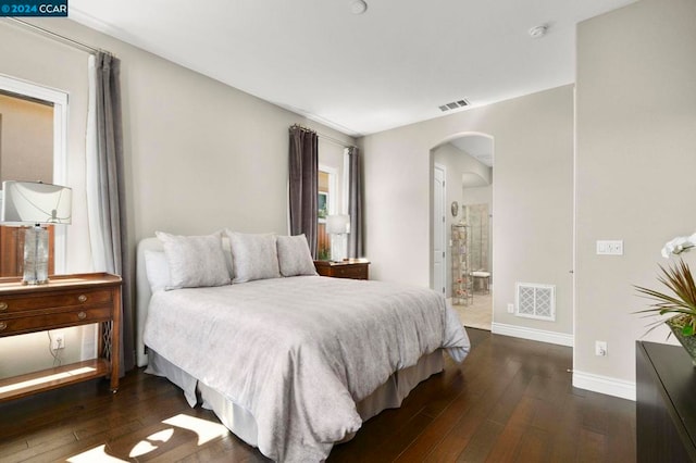 bedroom with dark hardwood / wood-style floors and ensuite bath