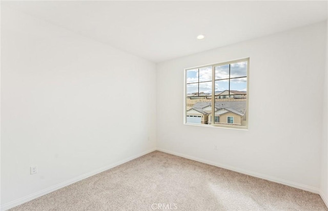 spare room with recessed lighting, baseboards, and light carpet