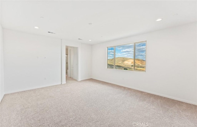 unfurnished room featuring recessed lighting, visible vents, baseboards, and light colored carpet