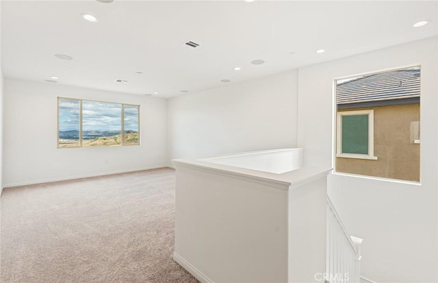 empty room featuring recessed lighting, light colored carpet, visible vents, and baseboards