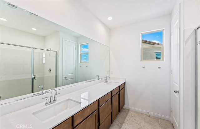 full bath with double vanity, visible vents, a stall shower, and a sink