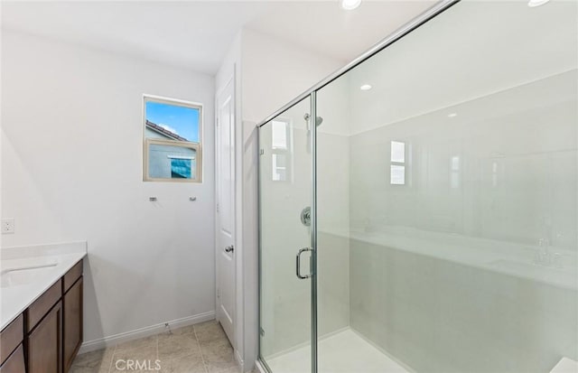 full bathroom with baseboards, a stall shower, vanity, and tile patterned flooring