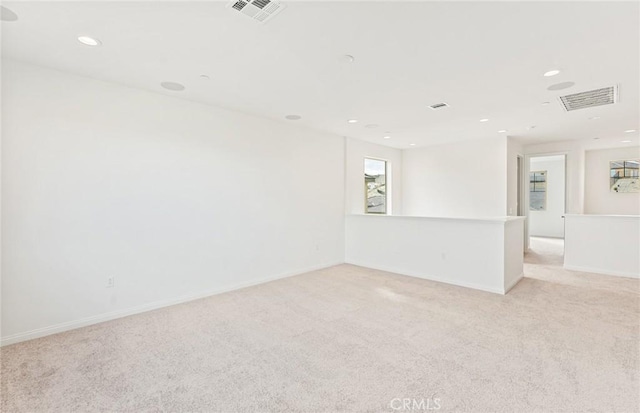 empty room with recessed lighting, visible vents, and light carpet