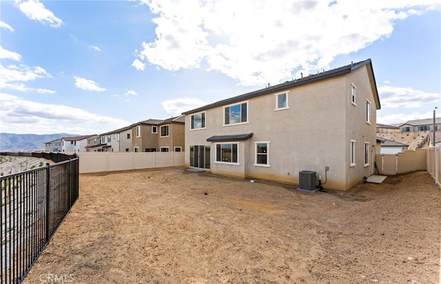 back of house with stucco siding, cooling unit, and a fenced backyard