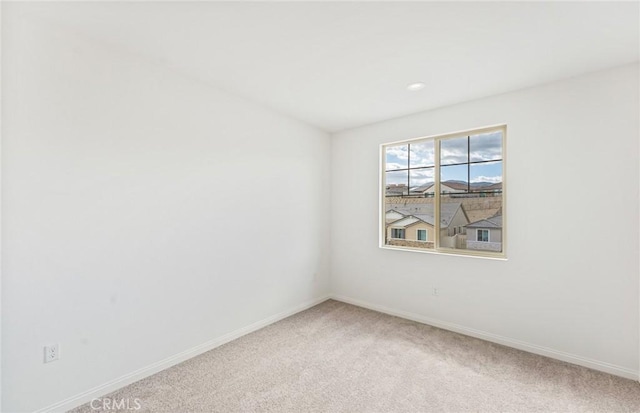 unfurnished room featuring recessed lighting, light colored carpet, and baseboards