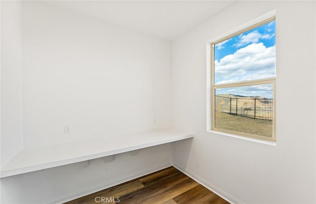 unfurnished office with dark wood-style floors and baseboards