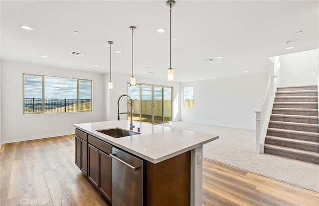 kitchen with visible vents, a sink, stainless steel dishwasher, open floor plan, and dark brown cabinetry