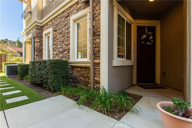 view of exterior entry with central air condition unit