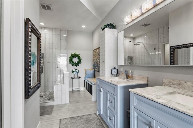 bathroom featuring vanity and tiled shower