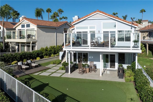 rear view of property with a patio and a balcony