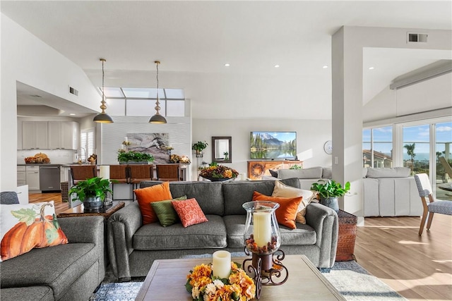 living room with light hardwood / wood-style flooring and high vaulted ceiling