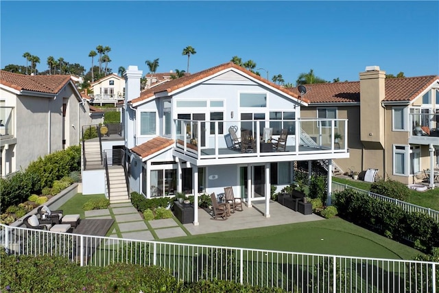 rear view of property featuring a patio area and a balcony