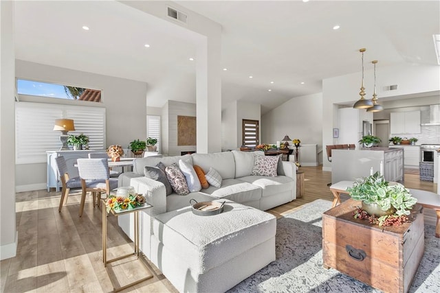 living room featuring light hardwood / wood-style flooring and vaulted ceiling