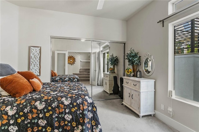 carpeted bedroom with ceiling fan, multiple windows, and a closet