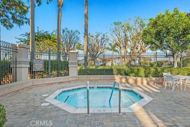 view of pool with a hot tub