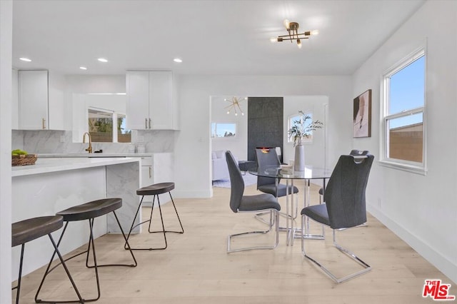 dining area featuring a healthy amount of sunlight, light hardwood / wood-style floors, and sink