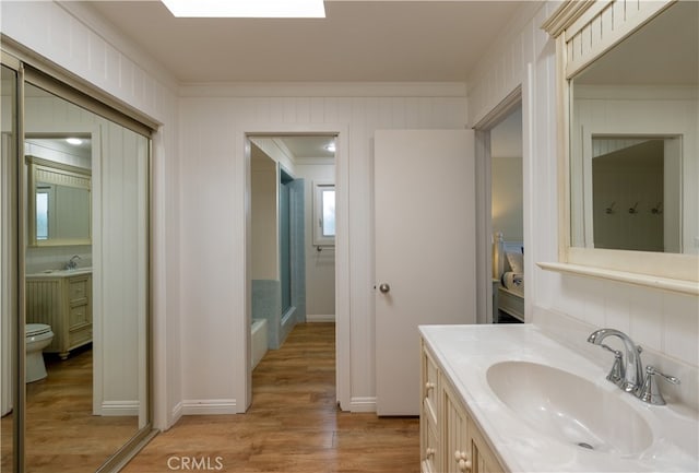 bathroom featuring ornamental molding, vanity, toilet, and hardwood / wood-style flooring