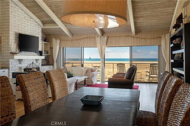 dining space featuring hardwood / wood-style flooring, wood ceiling, lofted ceiling with beams, and a wealth of natural light