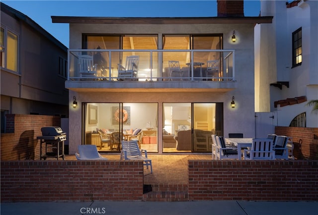 rear view of house featuring a patio and a balcony