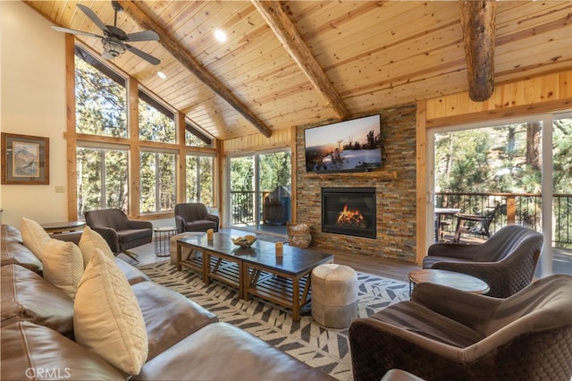 living room with a fireplace, ceiling fan, beamed ceiling, and high vaulted ceiling