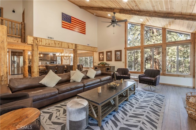 living room featuring hardwood / wood-style flooring, ceiling fan with notable chandelier, high vaulted ceiling, and a healthy amount of sunlight