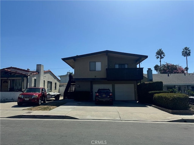 view of front of house with a garage, concrete driveway, and stairway