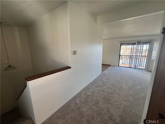 hallway with carpet and an upstairs landing