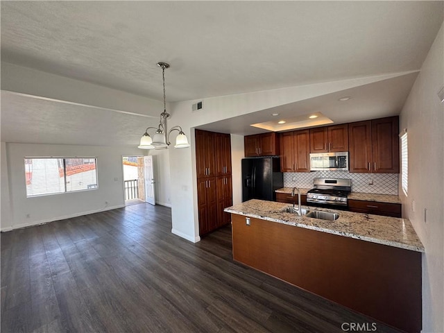 kitchen with stainless steel appliances, dark wood-type flooring, a peninsula, a sink, and backsplash