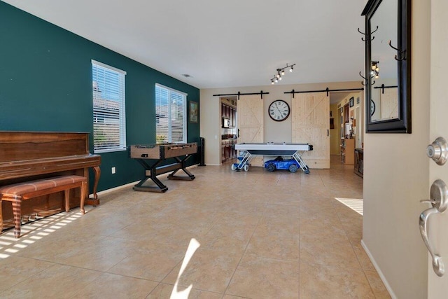 miscellaneous room featuring a barn door and light tile patterned flooring