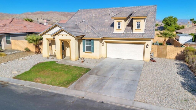 view of front of property with a mountain view, a garage, and a front lawn