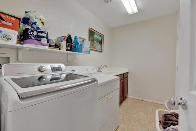 laundry room featuring washer and dryer, cabinets, light tile patterned floors, and sink