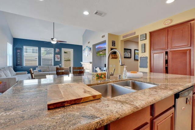 kitchen with light stone countertops, ceiling fan, sink, dishwasher, and lofted ceiling