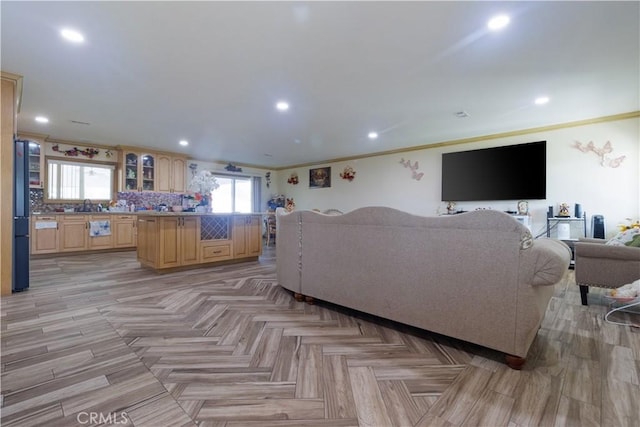 living room featuring light parquet floors, sink, and ornamental molding