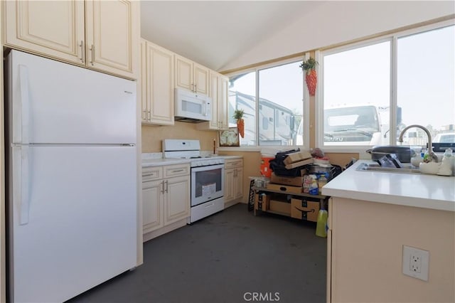 kitchen with sink, white appliances, and lofted ceiling